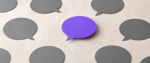 A purple speech bubble standing out among grey speech bubbles, illustrating call to action copy